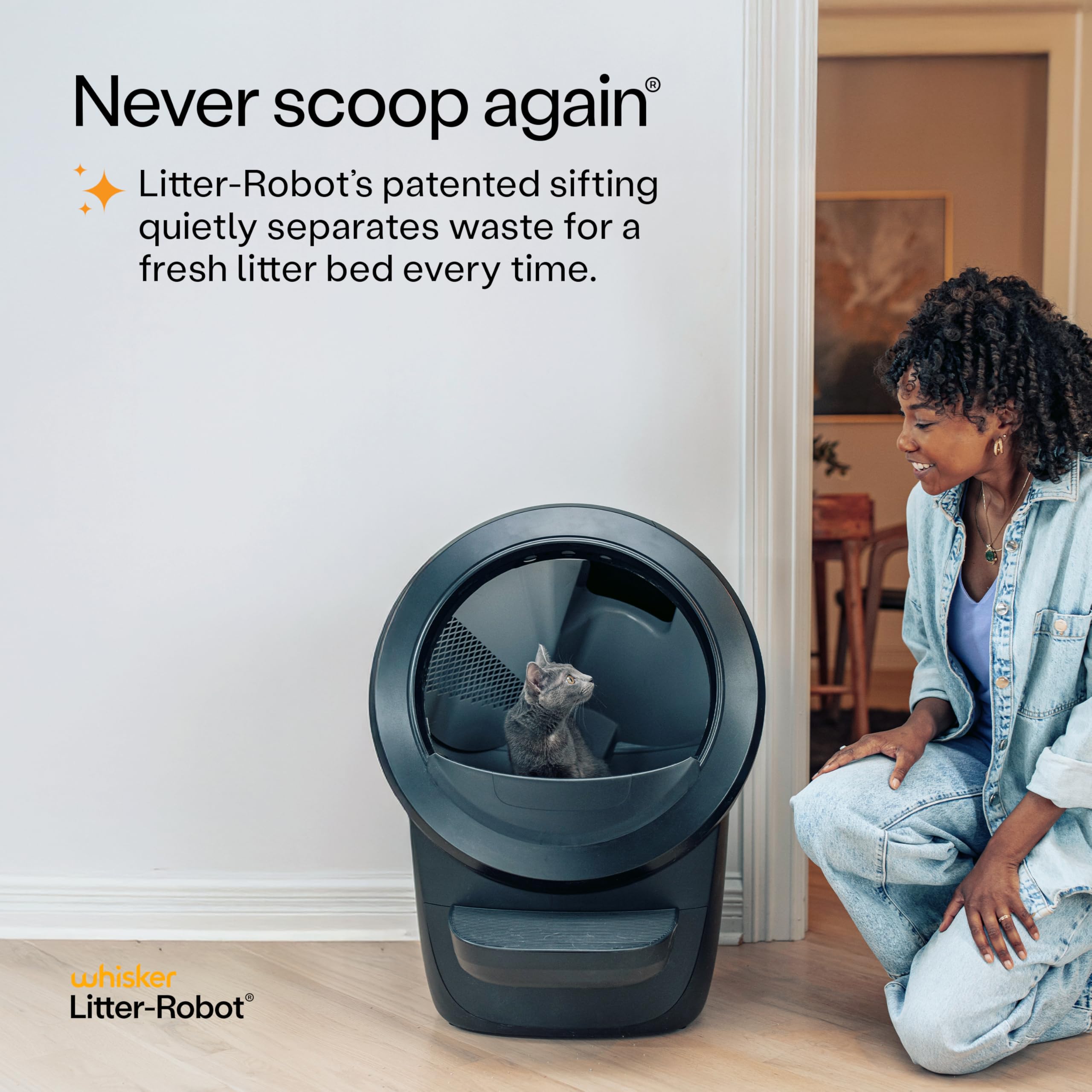 Whisker Litter-Robot with cat and smiling owner beside unit in home interior Litter-Robot 4 supply bundle